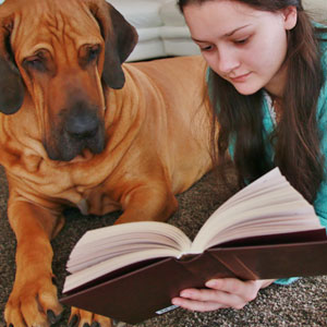 Dogs Help Children Read - Girl reads to dog.